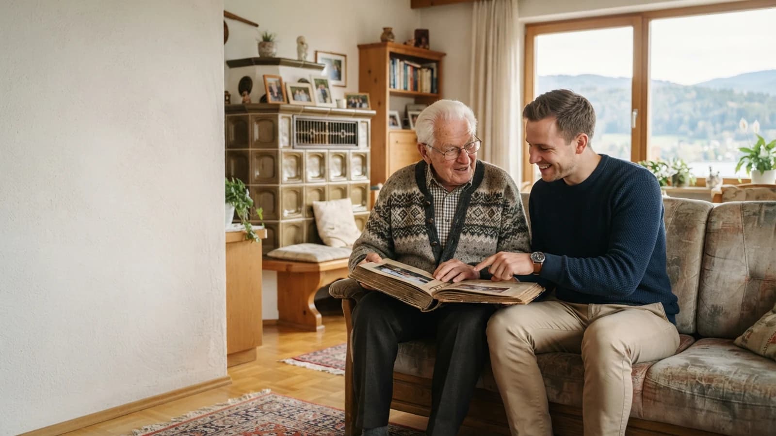 Symbolbild: Senior und Betreuer beim Ansehen eines Fotoalbums in einer Wohnung in Kärnten